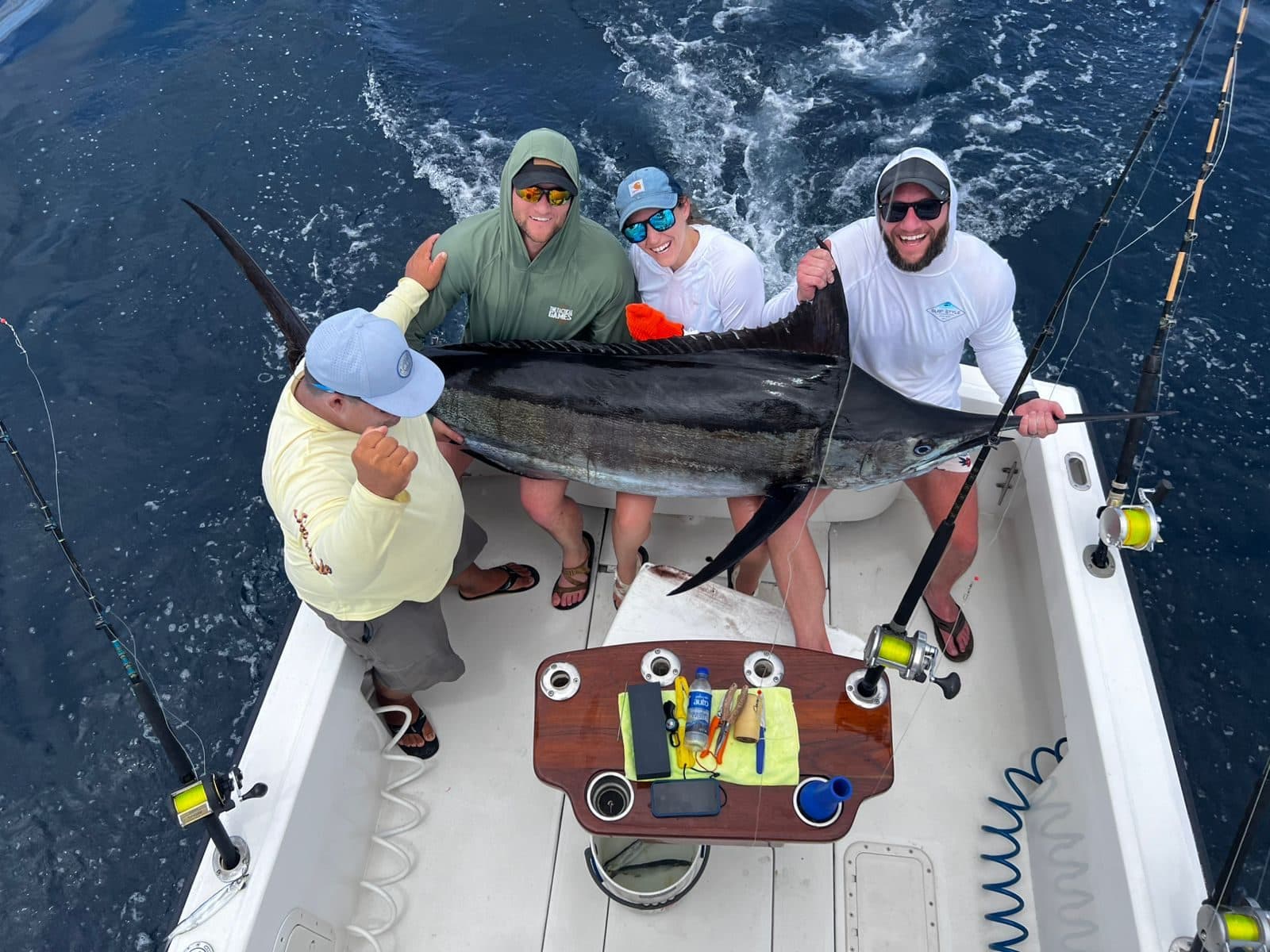 Four anglers and the captain with a large billfish in the cockpit