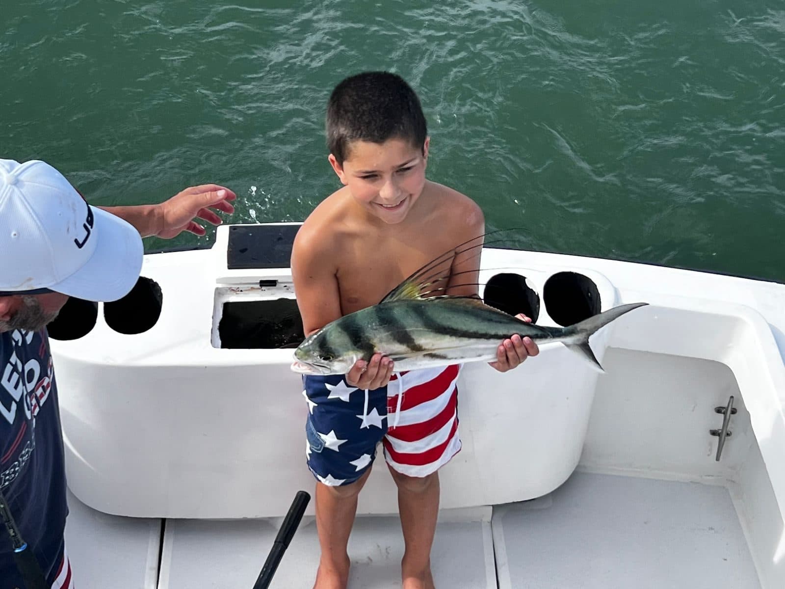 Young angler proudly holding his roosterfish